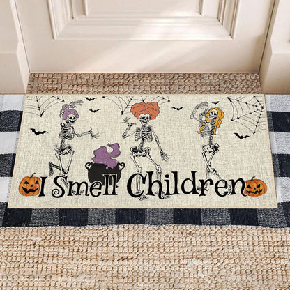 A rectangular Halloween doormat with a burlap-textured cream background, featuring three dancing skeletons, black spiderwebs, bats, a cauldron, and the phrase “I Smell Children” in black script. The mat is shown on a porch step over a woven rug and a black-and-white checkered floor mat.