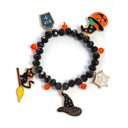 Black beaded charm bracelet with Halloween-themed charms including a witch hat, spider web, cat on broom, shield, and pumpkin, shown on a white background with a 16cm measurement overlay.