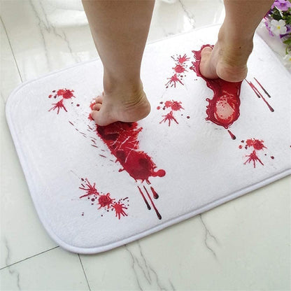 White bath mat with red blood splatter design on a white floor.
