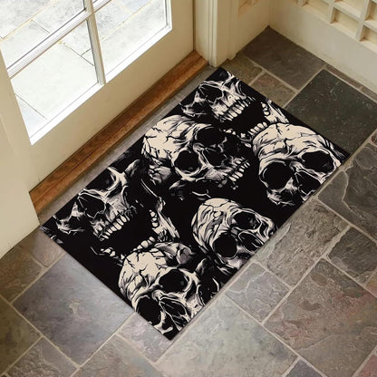 A rectangular black doormat with a repeating white and gray skull pattern, placed on a gray stone tile floor in front of a glass door.