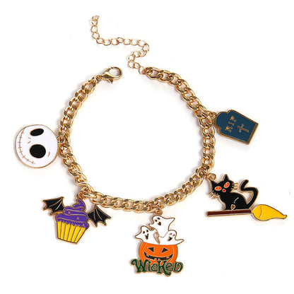 A gold-tone charm bracelet featuring multiple Halloween-themed enamel pendants, including Jack Skellington, a tombstone, a black cat on a broom, a cupcake, a pumpkin with ghosts, and the word 'Wicked', shown on a plain white background.
