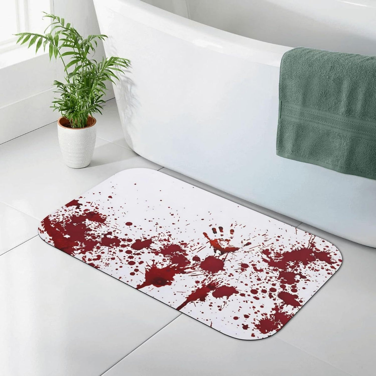 A white bath mat with a dark red blood splatter pattern, placed on a light gray tiled bathroom floor next to a white bathtub with a green towel.
