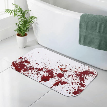A white bath mat with a dark red blood splatter pattern, placed on a light gray tiled bathroom floor next to a white bathtub with a green towel.