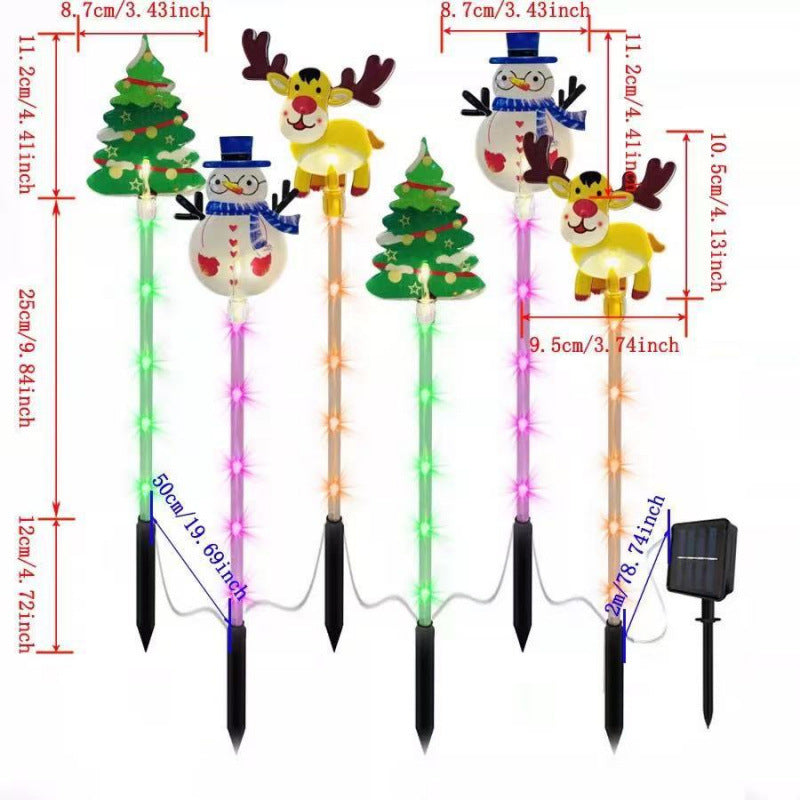 Four festive outdoor Christmas yard stake decorations shown on a white background with dimension callouts and a small solar panel accessory. The set includes two Christmas trees, two snowmen, and two reindeer figures with multicolor LED lights and black ground stakes.
