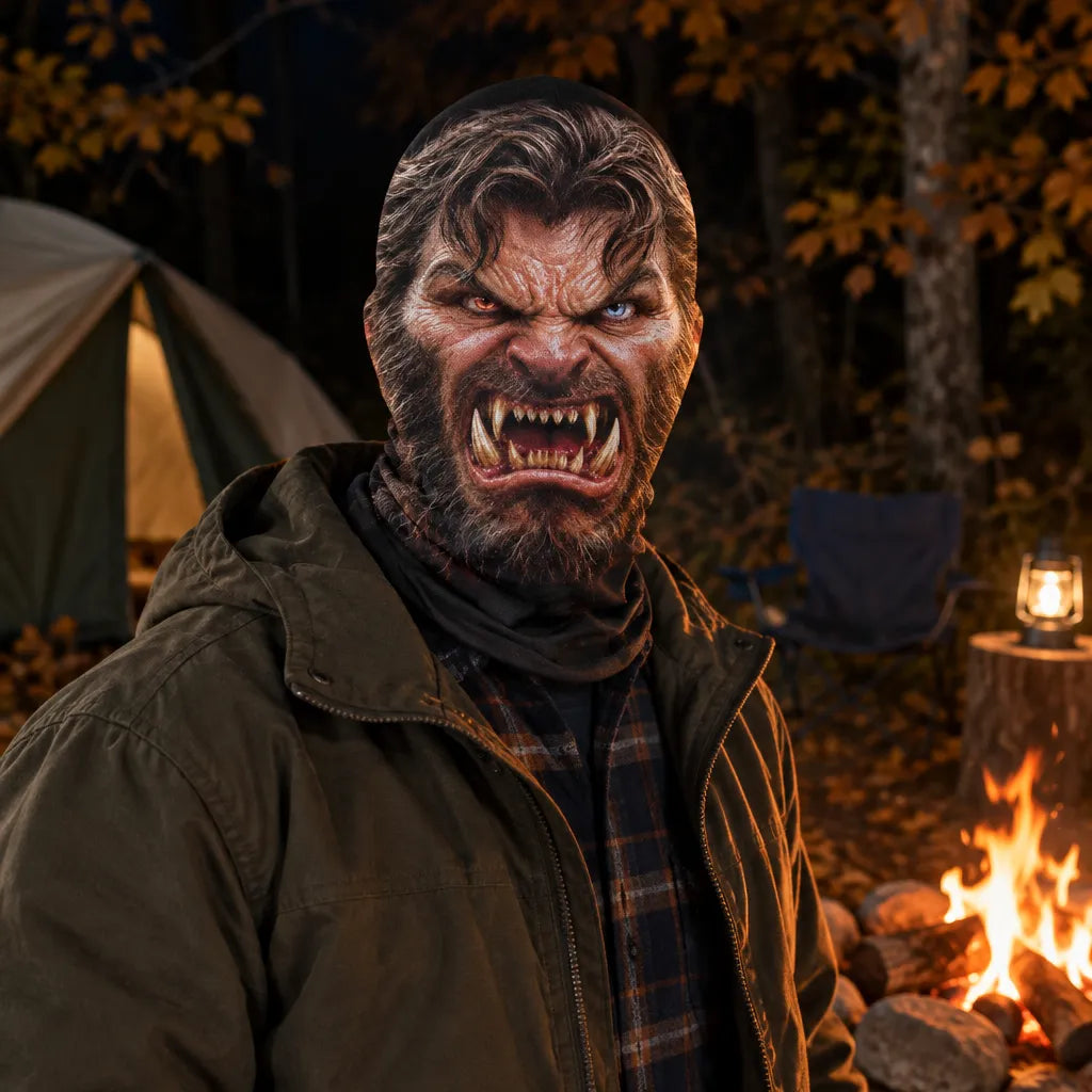 A person wearing a detailed werewolf mask with bared fangs and a snarling expression, standing outdoors at night near a campfire, tent, and lantern.